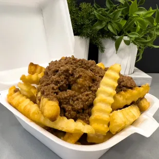 a container of french fries with ground beef