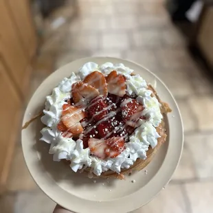 a waffle topped with whipped cream and strawberries