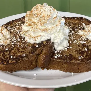 a plate of french toast with whipped cream