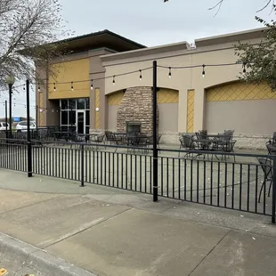 the outside of a restaurant with tables and chairs
