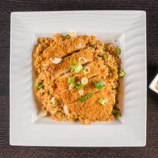 Crispy Fried Chicken over Fried Rice. Battered and deep-fried chicken fillet over specialty fried rice.