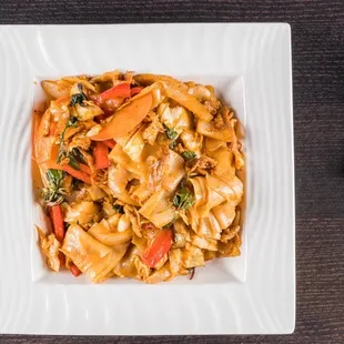 Pa Ke Mao（Drunken noodles）thick rice noodle stir fried with bell peppers，tomatoes，carrots，basil and choice of protein