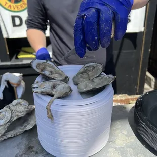 a man holding a bucket of oysters