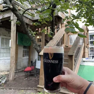 a hand holding a pint of guinness