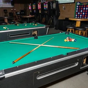two pool tables with cues