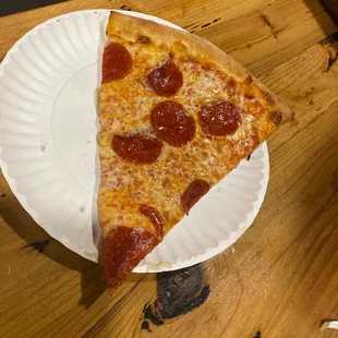 a slice of pizza on a paper plate