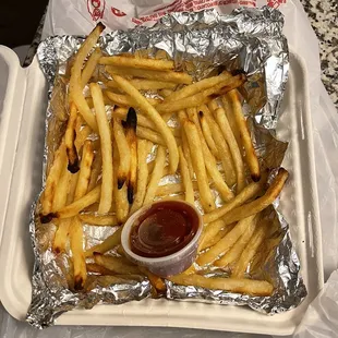 a tray of french fries with ketchup