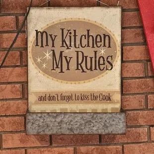 a sign that says my kitchen is my rules and don&apos;t forget to kiss the cook