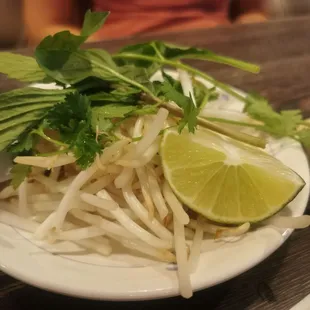 a plate of noodles and a lime