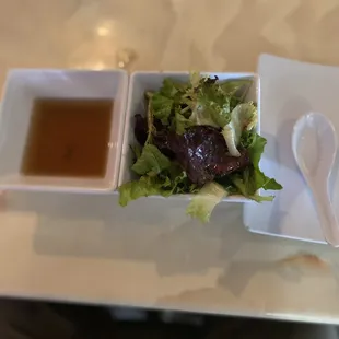 a salad with a side of dipping sauce