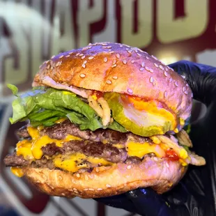 a hand holding a hamburger