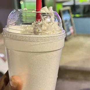 a hand holding a cup of ice cream