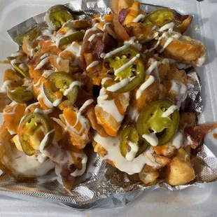a plate of nachos with cheese and jalapenos