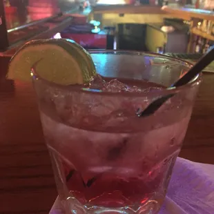 a cocktail in a glass with a lime wedge