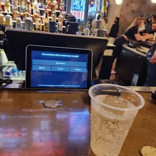 a drink and a laptop on a bar
