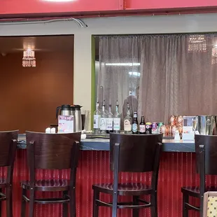 a bar with stools and bottles of liquor