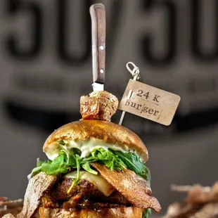 Wagyu beef patty comes w/ a golden touch of 24-karat gold-dusted &apos;billionaire&apos; bacon, rich truffle cheese, fresh arugula, &amp; savory bacon jam