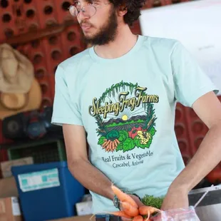 a man holding a bunch of carrots