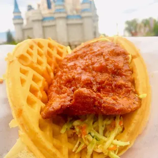Sweet and spicy chicken waffle sandwich in front of Cinderella&apos;s Castle