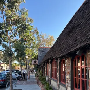 a view of a sidewalk with parked cars