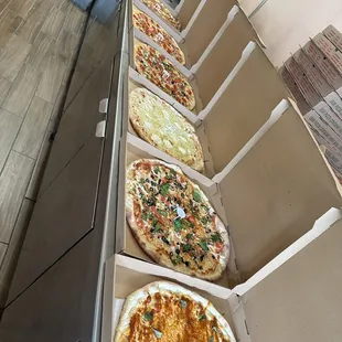 a row of pizzas with different toppings