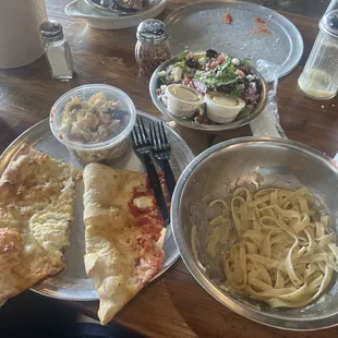 pizza, pasta, and salad on a table