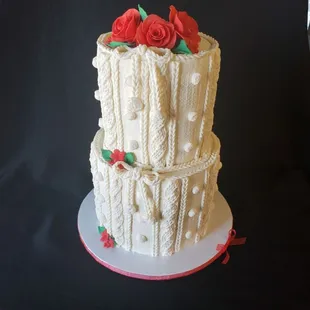 a three tiered cake with red roses