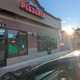 a car parked in front of a pizzaria