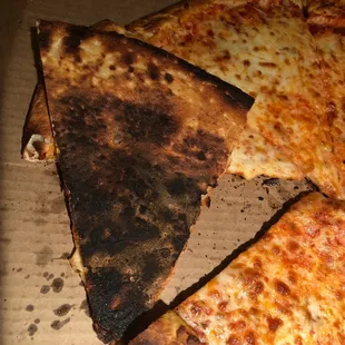 a burnt pizza in a box