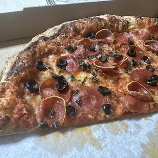 Regular pepperoni, pepperoni cups, black olives and fresh basil on an XL New York style