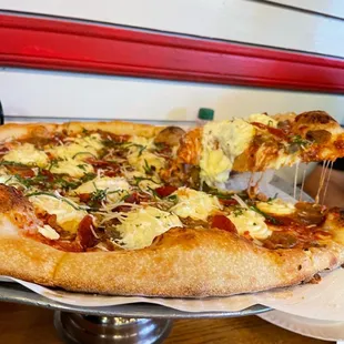 a pizza being lifted by a spatula