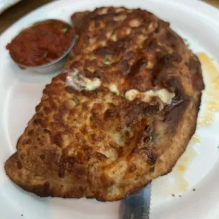 a slice of pizza on a plate with a knife