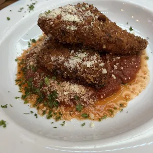 a plate of meatballs with sauce and parmesan cheese