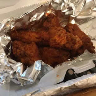 fried chicken in foil on a table