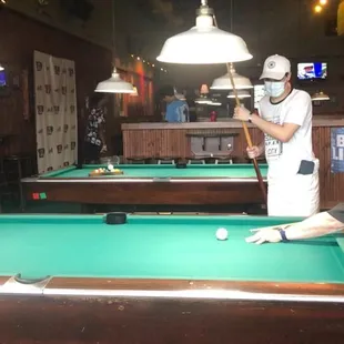 1 man breaking, 1 boy holding a cue