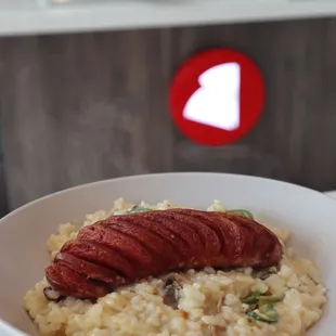 a plate of risotto with a hot dog