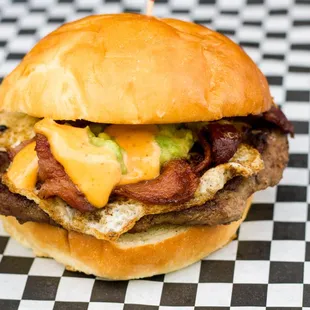 a burger with bacon, cheese, and lettuce