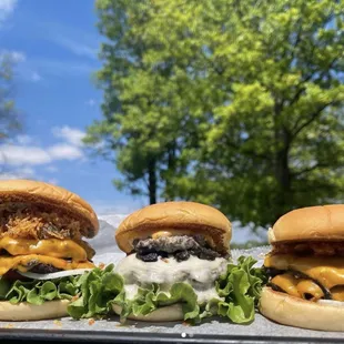 three burgers with cheese and lettuce