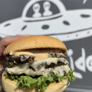 a hand holding a hamburger