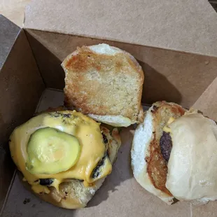 One and a half of an all-american slider burger - beef, American cheese and pickle slice