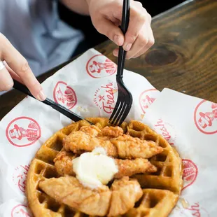 a person eating chicken and waffles