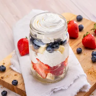 strawberries, blueberries, and whipped cream in a jar