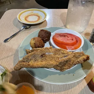 Catfish platter with extra filet and jalapeño hush puppies. You only need one filet. The tomatoes as a side were excellent.