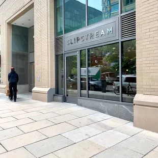 a man walking down a sidewalk in front of a building