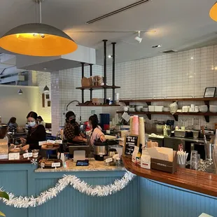 people sitting at the counter of a coffee shop