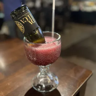 a bottle of wine in a glass