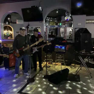 a man playing a guitar and singing into a microphone