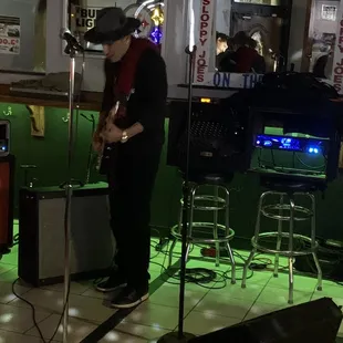 a man playing guitar in a bar