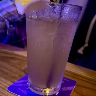 a purple drink with a lemon wedge
