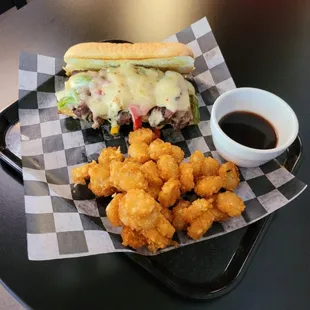 a sandwich and tater tots on a tray